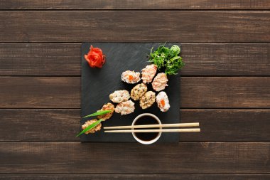 Suşi maki ve rulo siyah rustik ahşap.