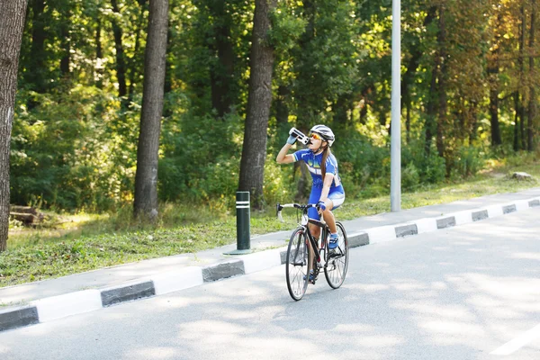 Kobiet rowerzysta pije wodę w wyścigu, przerwa — Zdjęcie stockowe