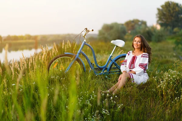 Mujer joven en traje popular ucraniano nacional con bicicleta — Foto de Stock