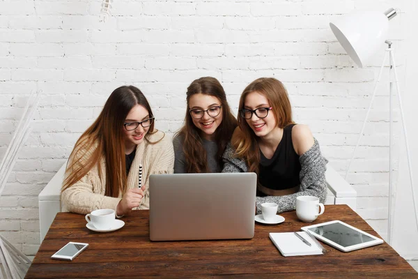 Portret van drie lachen vriendinnen met laptop. — Stockfoto