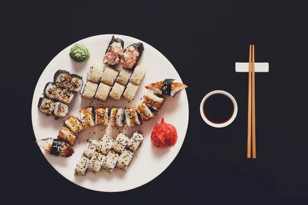 Zestaw sushi maki i rolki w czarny drewno rustykalne. — Zdjęcie stockowe