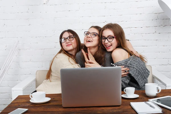 Porträt von drei lachenden Freundinnen mit Laptop. — Stockfoto