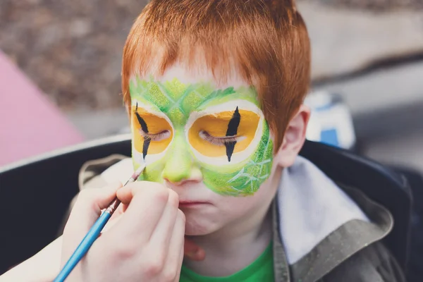 Дитячий процес малювання обличчя у рудого хлопчика — стокове фото