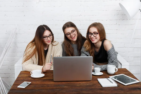 Portrait of three laughing girlfriends with laptop. — Stock Photo, Image