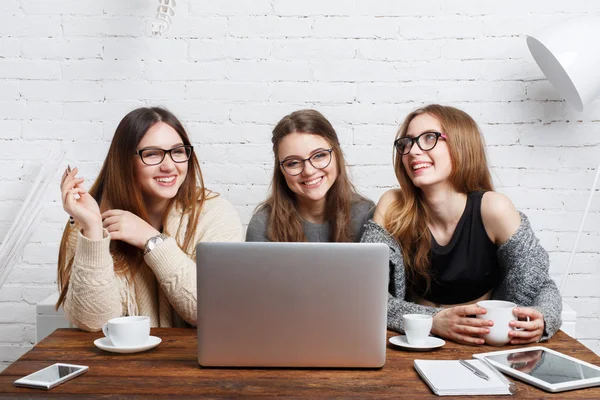 Portret van drie lachen vriendinnen met laptop. — Stockfoto