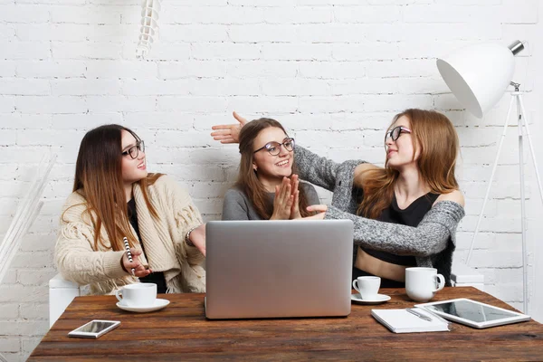 Porträt von drei lachenden Freundinnen mit Laptop. — Stockfoto