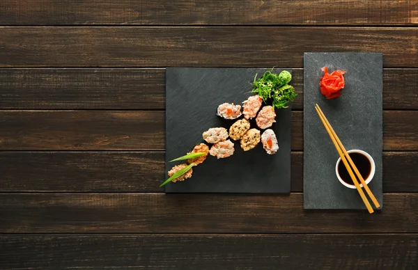 Uppsättning av sushi maki och rullar på svart rustikt trä. — Stockfoto