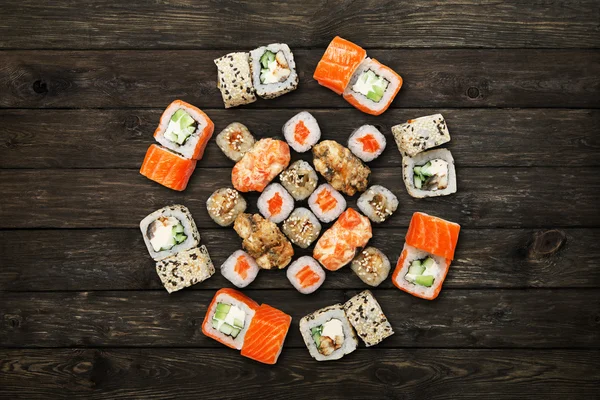 Set of sushi maki and rolls at black rustic wood. — Stock Photo, Image