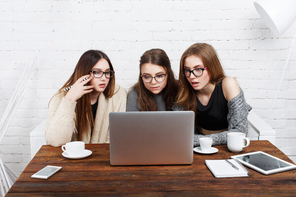 Three young women friends with laptop.