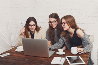 Dizüstü bilgisayar ile üç genç kadın arkadaş.