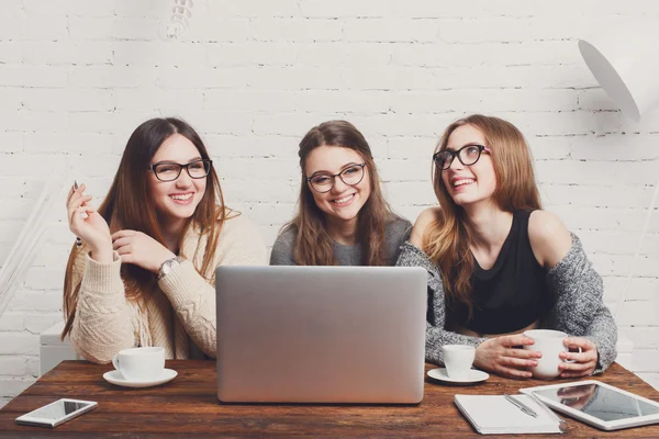 Portret van drie lachen vriendinnen met laptop. — Stockfoto