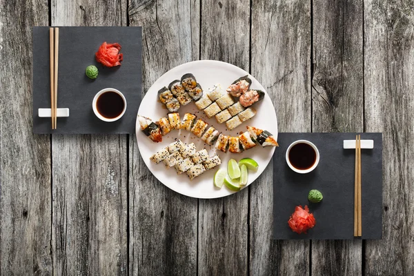 Set Sushi Maki und Rollen aus rustikalem schwarzem Holz. — Stockfoto