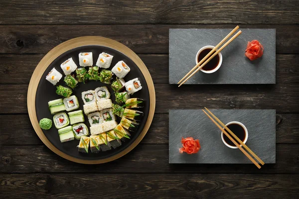 Set de sushi maki y rollos en madera rústica . — Foto de Stock