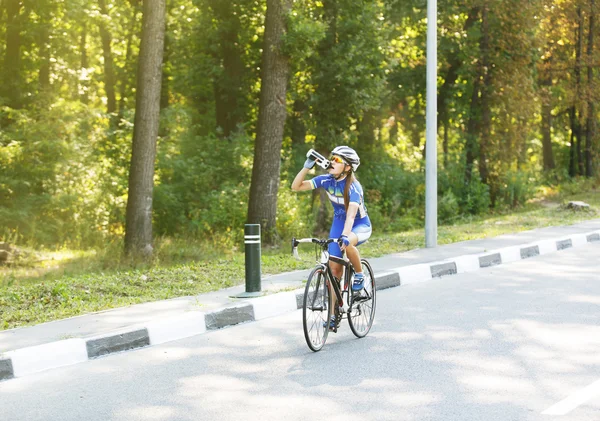 Sede. Ciclista fêmea bebe água perto de bicicleta — Fotografia de Stock