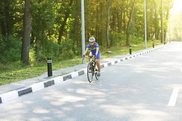 骑单车的女子在道路上骑着一辆赛车 — 图库照片