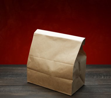Kahverengi kraft kağıt torba öğle veya ahşap masa üstünde yiyecek