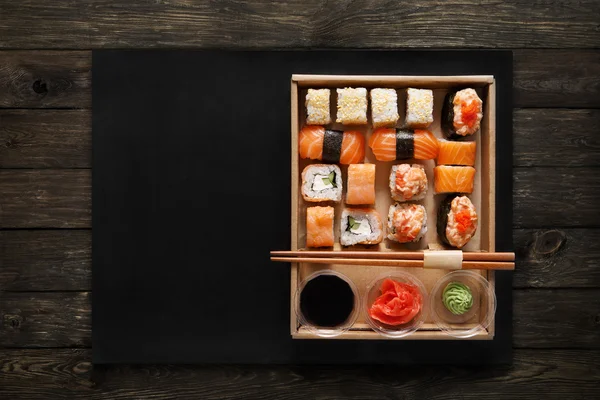 木の上の箱に寿司巻きとロールのセット. — ストック写真