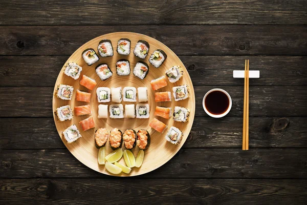 Set of sushi maki and rolls at wood background — Stock Photo, Image