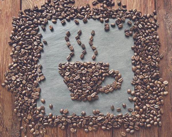 Copo de grãos de café no fundo de pedra — Fotografia de Stock