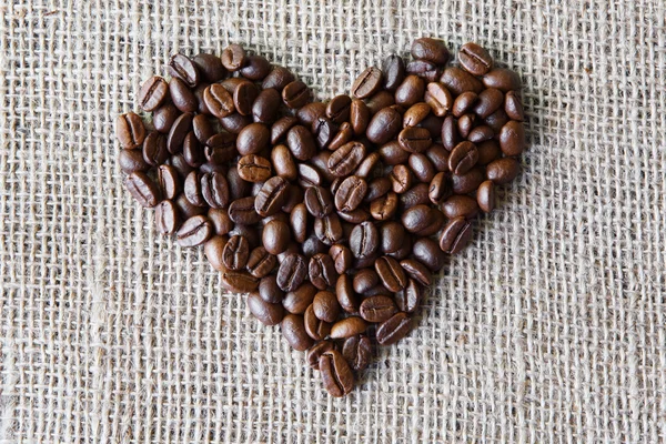 Textura de arpillera con granos de café en forma de corazón — Foto de Stock