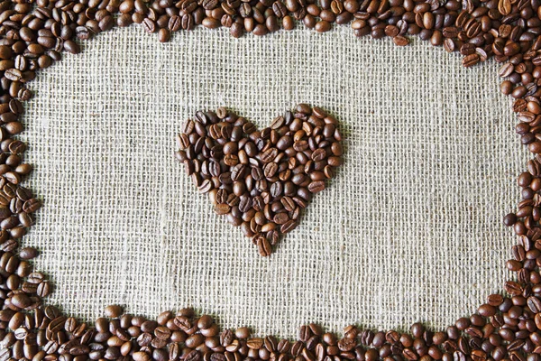 Textura de serapilheira com grãos de café forma do coração — Fotografia de Stock