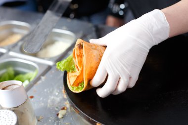 Satıcı açık havada sebzeli krep yapıyor