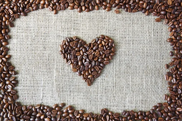 Texture toile de jute avec grains de café en forme de coeur — Photo