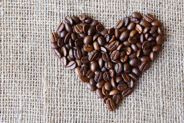 Textura de arpillera con granos de café en forma de corazón — Foto de Stock