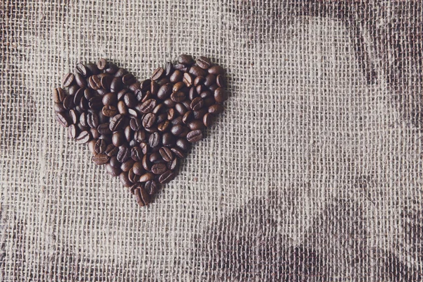 Texture toile de jute avec grains de café en forme de coeur — Photo