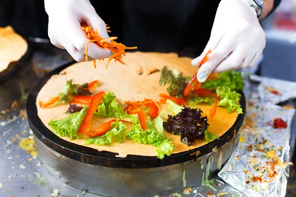 Vendor making crepe with vegetables outdoors — Stock Photo, Image