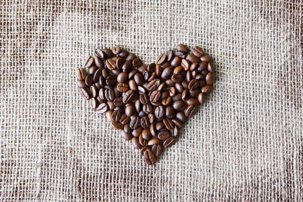 コーヒー豆ハート型に黄麻布のテクスチャ — ストック写真