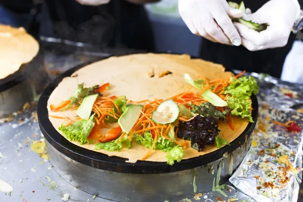 Vendor making crepe with vegetables outdoors — Stock Photo, Image