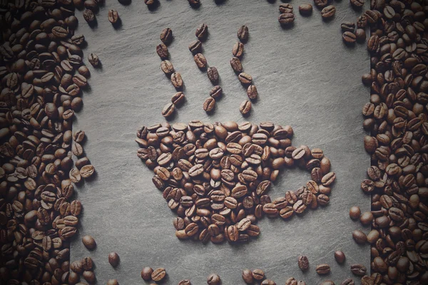 Copo de grãos de café no fundo de pedra — Fotografia de Stock