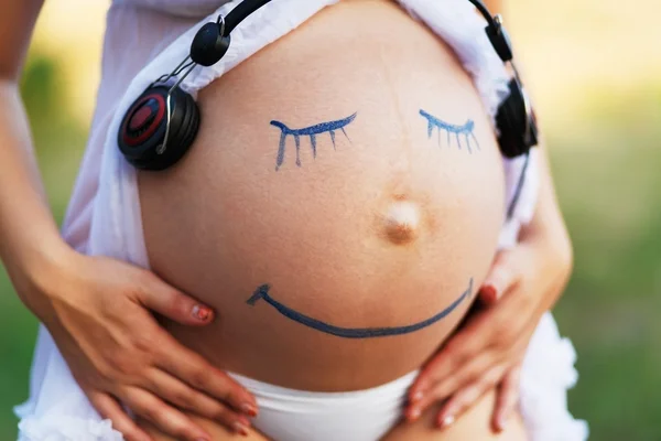 Mulher grávida barriga closeup com sorriso rosto engraçado — Fotografia de Stock