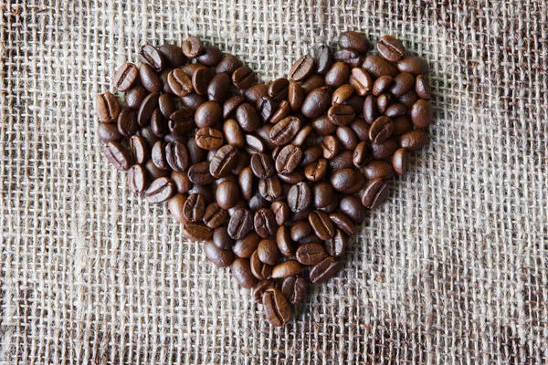 Textura de arpillera con granos de café en forma de corazón — Foto de Stock