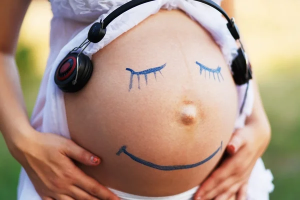 Embarazada mujer vientre primer plano con sonrisa cara divertida —  Fotos de Stock