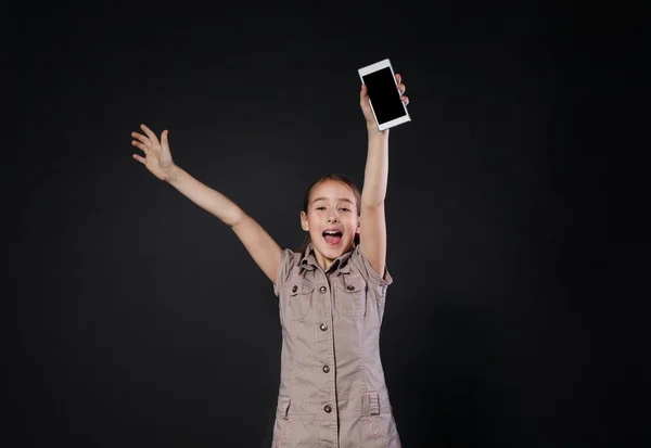 Gelukkig klein meisje smartphone in de hand houden op zwarte achtergrond — Stockfoto