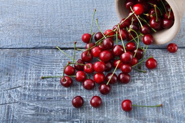 Taze kiraz closeup mavi rustik ahşap üzerine yeşil yaprakları ile
