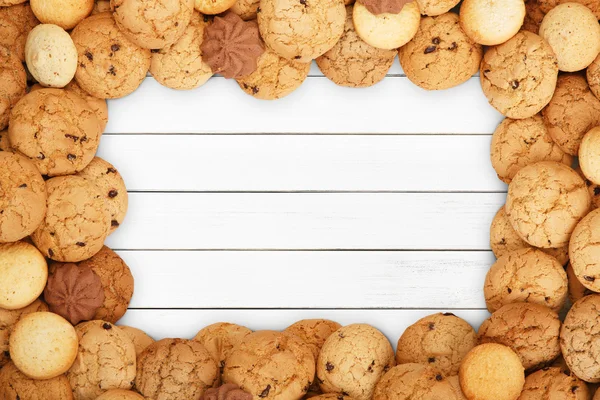 Biscoitos e biscoitos em madeira branca com espaço de cópia — Fotografia de Stock