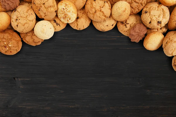 Biscoitos e biscoitos em madeira preta com espaço de cópia — Fotografia de Stock