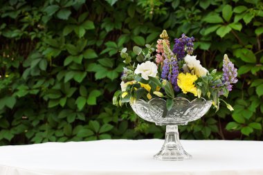 Güzel çiçek buketi açık havada. Beyaz masa bitki dekorasyon düğün