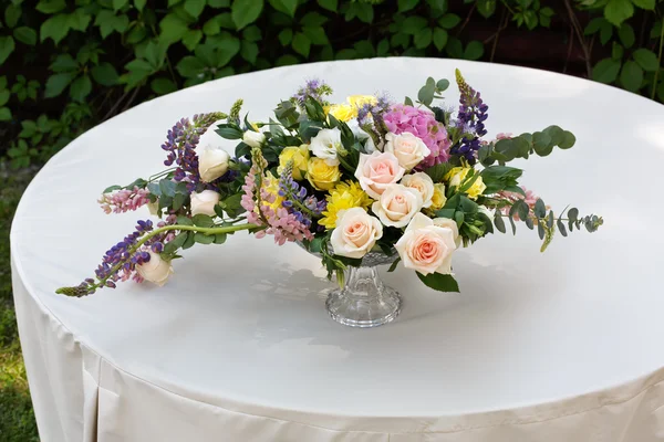 Bellissimo mazzo di fiori all'aperto. Matrimonio decorazione floristica a tavola bianca — Foto Stock