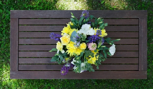 Красивий квітковий букет на відкритому повітрі на дерев'яному столі вид зверху — стокове фото