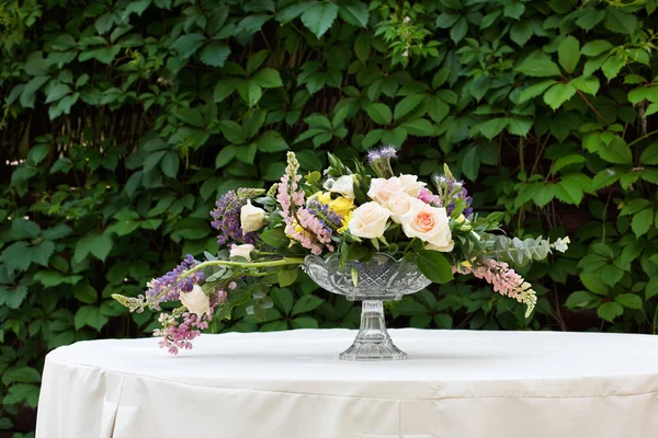 屋外の美しい花の花束。結婚式の白いテーブルで花の装飾 — ストック写真