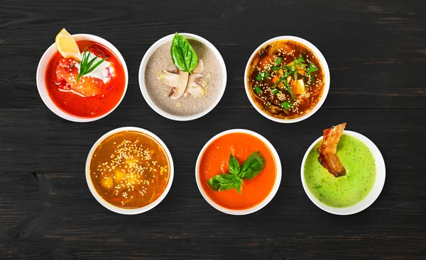 Variety of soups at black wood, top view — Stock Image Variety of soups at black wood, top view Stock Image