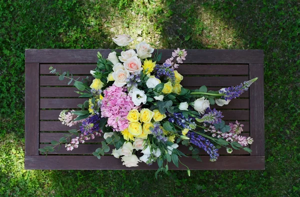 Hermoso ramo de flores al aire libre en la mesa de madera vista superior — Foto de Stock