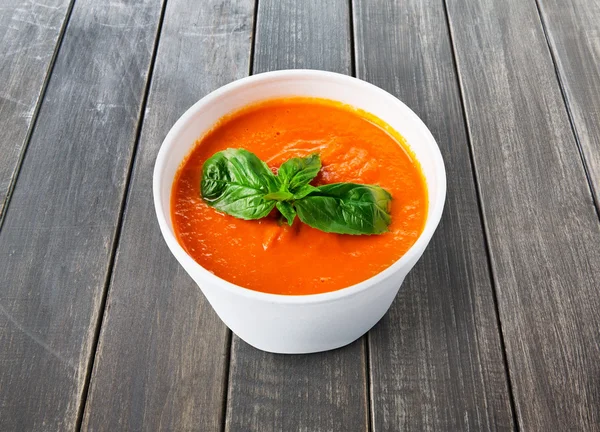 Lieferung von warmem Essen - Tomaten-Gazpacho-Suppe auf grauem Holz — Stockfoto