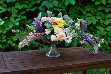 Güzel çiçek buketi açık havada. Ahşap masa, bitki dekorasyon düğün