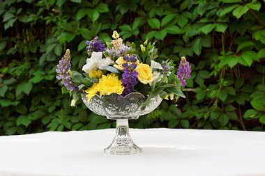 Güzel çiçek buketi açık havada. Beyaz masa bitki dekorasyon düğün