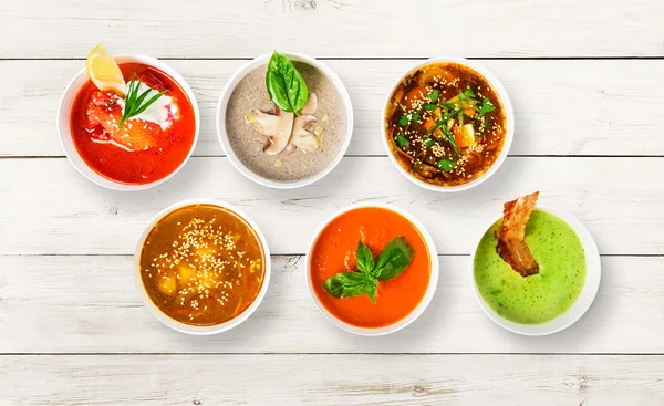 Variety of soups at white wood, top view — Stock Photo, Image